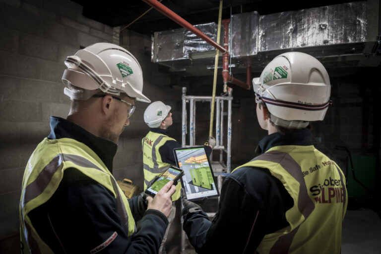 men at construction site using Dalux Field on mobile and tablet
