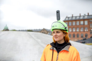 SiteWalk woman wearing 360 camera on helmet at a construction site